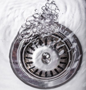 a clogged drain with water pooling in a sink