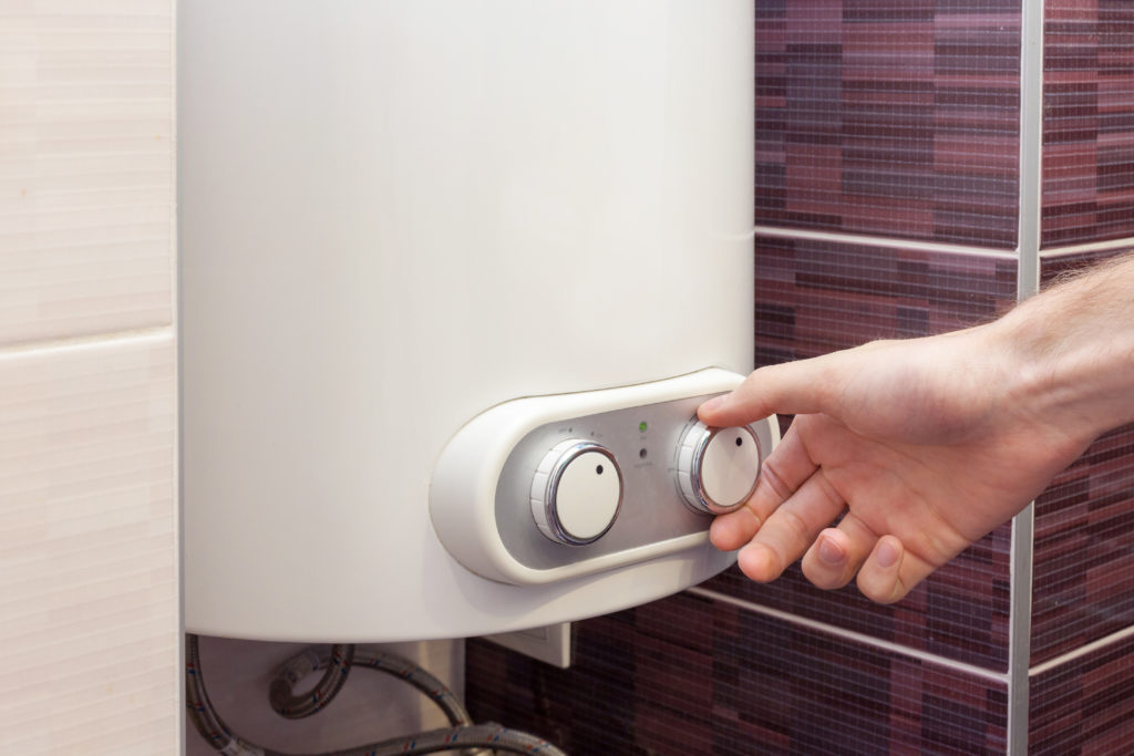 Close-up of man hands setting the temperature of water in Electric Boiler