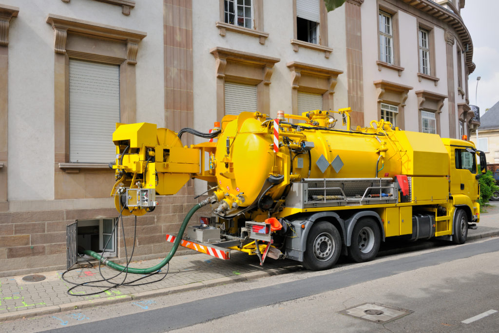 a sewage truck working on a restaurant