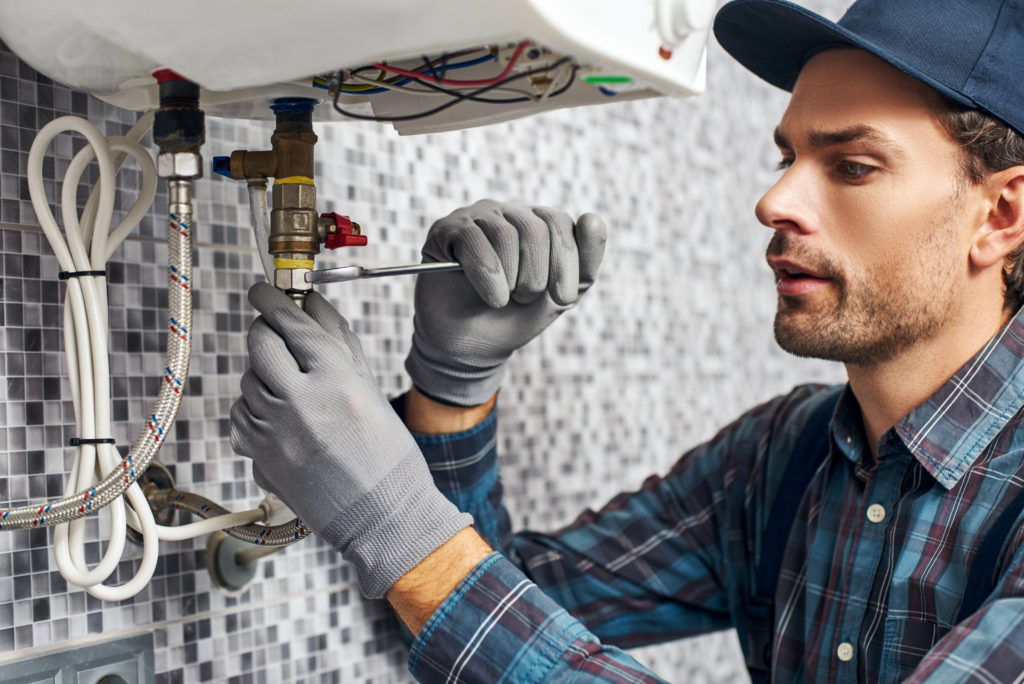 a plumber performing some plumbing repair on a sink