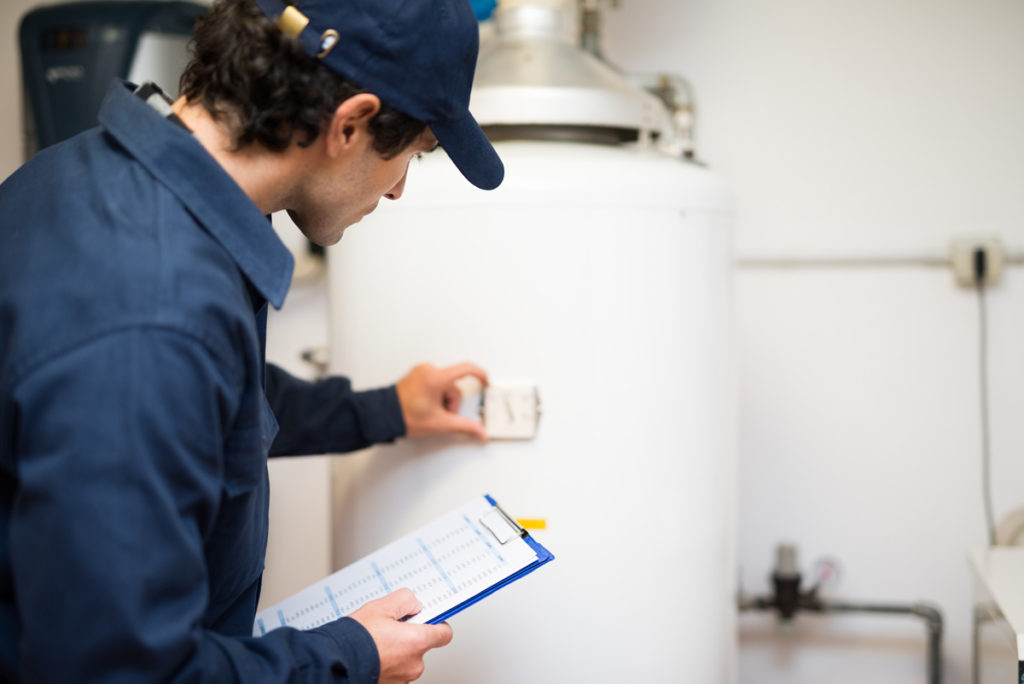 Plumber making a water heater repair in El Paso.