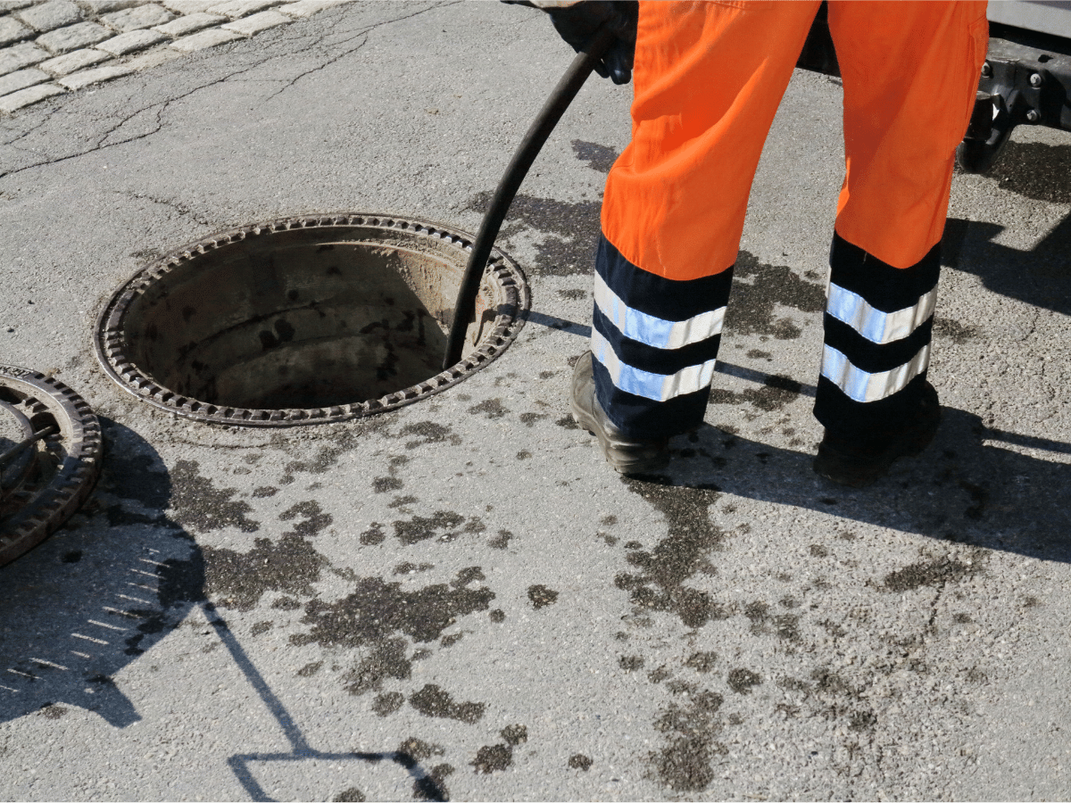Man cleaning out a sewer in the street